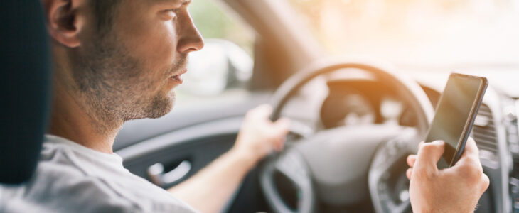 Careless driver using his mobile phone whilst driving a car