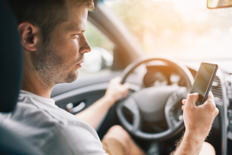 Careless driver using his mobile phone whilst driving a car