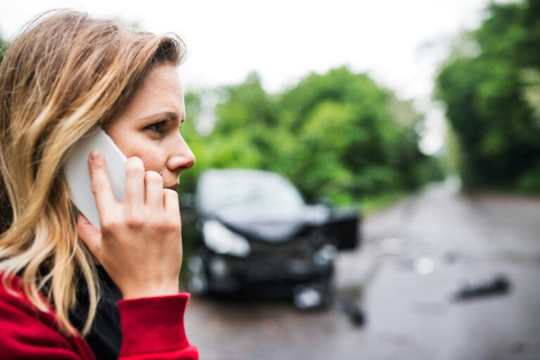 a woman calling the police after a car accident