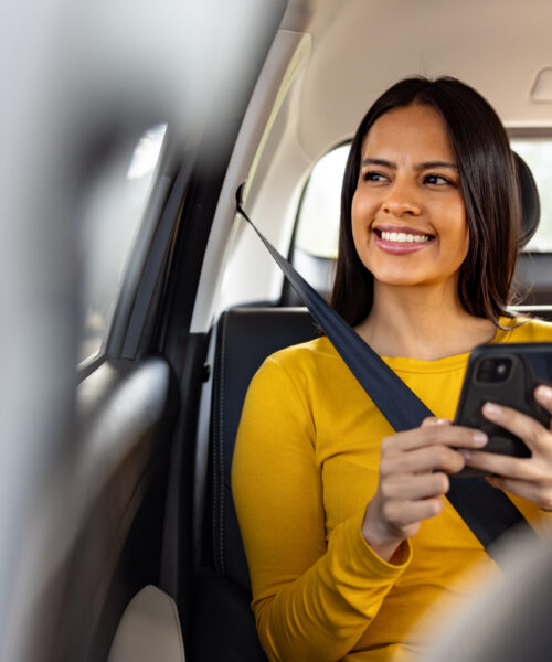 Happy Latin American woman riding in a car