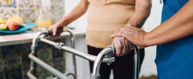 Nurse helping a senior woman walking at home