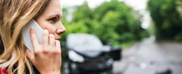 a woman calling the police after a car accident
